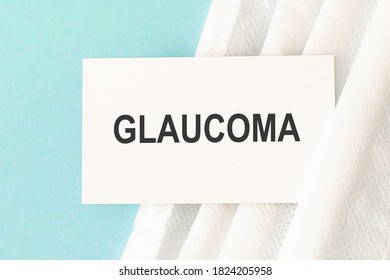 Word Glaucoma With Medical Mask On A Blue Background. Medicine Concept