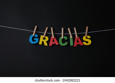 Word Gracias on black background.  Gracias is defined as thank you in Spanish.
