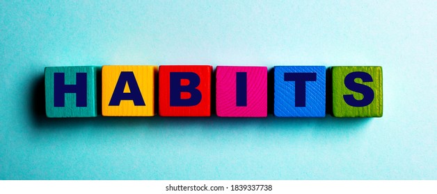 The word HABITS is written on multicolored bright wooden cubes on a light blue background - Shutterstock ID 1839337738