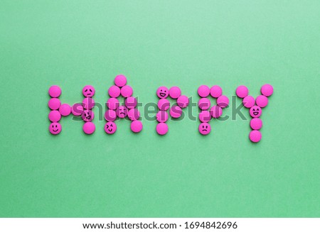 Word "Happy" made of pills on color background