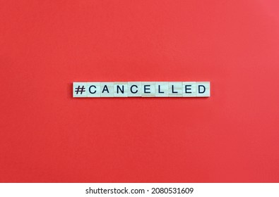 Word Сanceled and hashtag sign on wood bloks with lettering on red background. Cancel culture concept. Copy space.