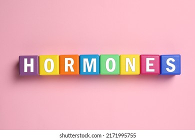 Word Hormones Made Of Colorful Cubes With Letters On Pink Background, Flat Lay