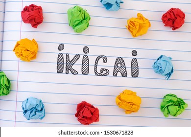 The word Ikigai on notebook sheet with some colorful crumpled paper balls around it. IKIGAI is a Japanese concept reason for being.