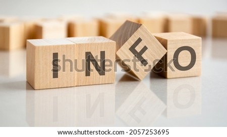 the word info is written on a wooden cubes structure. Blocks on a bright gray background. Selective focus.