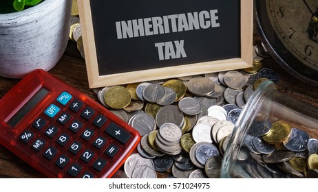 Word INHERITANCE TAX On Mini Chalkboard And Coin In The Jar With Red Calculator,green Plant And Clock On Wooden Base. Financial Concept.