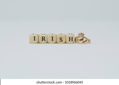 The word "Irish" is spelled out with letter blocks and it sits next to a Claddagh ring. This is a perfect image for St. Patrick's day or an Irish themed party. The claddagh ring symbolizes loyalty.