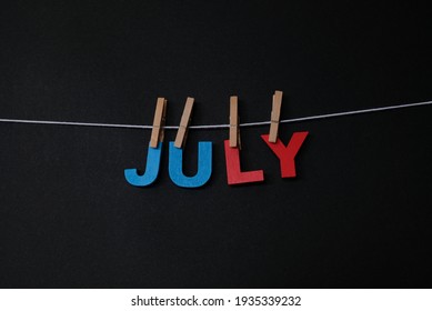 Word July On Black Background. July Is The Seventh Month Of The Year In The Julian And Gregorian Calendars.