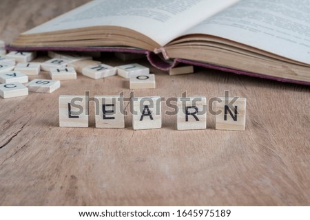 the word learn written with cube letters on wooden background