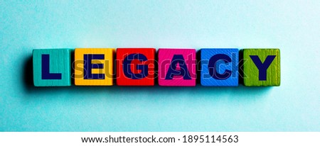 The word LEGACY is written on multicolored bright wooden cubes on a light blue background