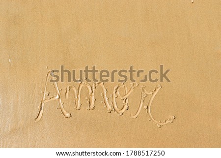 The word love in portuguese written on the beach sand / Amor escrito na areia da praia