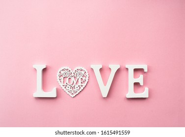 The word love in white letters on a trendy pink background. Happy Valentine's Day, Mother's Day, March 8, World Women's Day holiday card concept. Flat lay.
