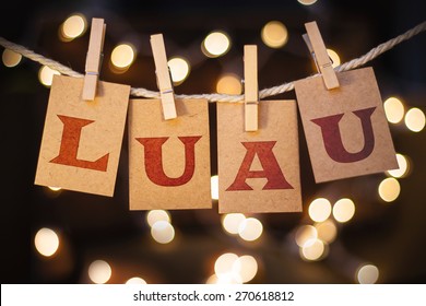 The word LUAU printed on clothespin clipped cards in front of defocused glowing lights.
