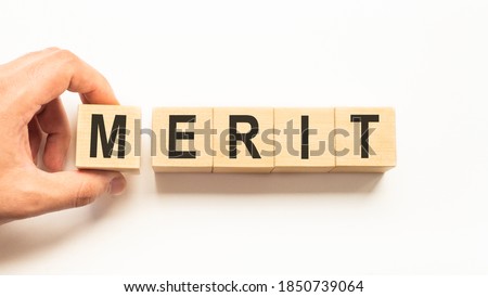 Word merit. Wooden small cubes with letters isolated on white background with copy space available.Business concept