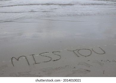 Word Miss You Written On Sand Beach  Beside Foamy Sea Wave