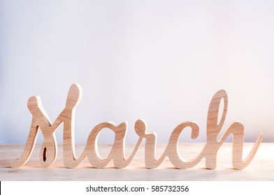 Word Month Of MARCH Carved In Wood With Light Background. Beginning Of Springtime. Spring Hello Concept