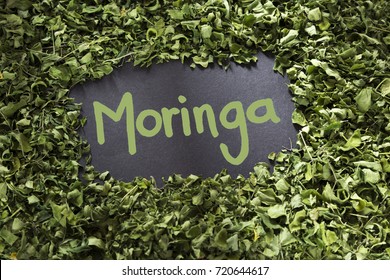 The word moringa in green color on a background of leaves - Moringa oleifera