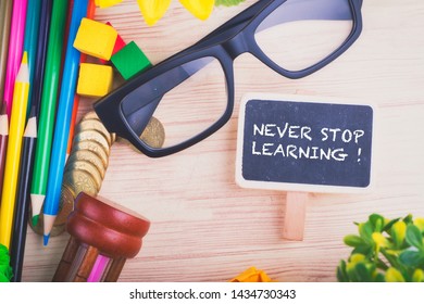 word NEVER STOP LEARNING over scattered wooden workspace