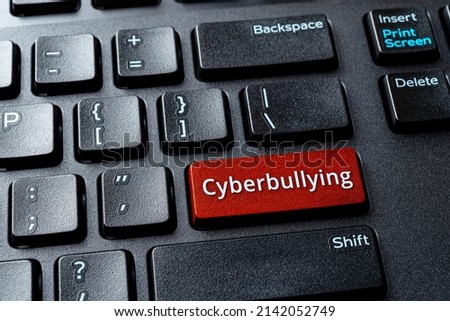 Сyberbullying word on a computer keyboard button. Laptop enter key with message cyberbullying. Concept of bullying, abusive or threatening writing or speech on the internet. Antisocial media. Top view