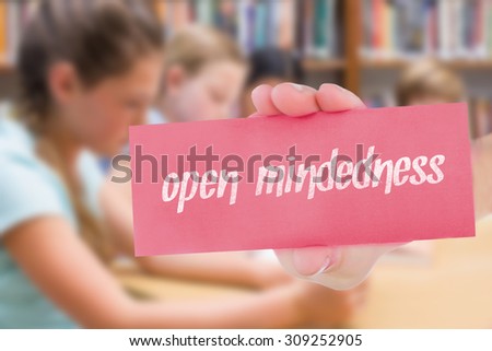 The word open-mindedness and hand showing card against cute pupil using tablet computer in library