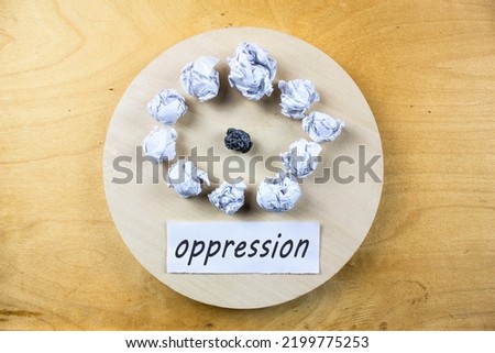 Word OPPRESSION on a piece of paper on a wooden table. The concept of oppression, bullying, ridicule, reproaches and swearing at work or in everyday life.