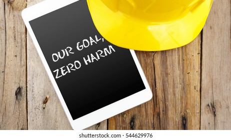 Word Our Goal, Zero Harm On Tablet With Yellow Safety Helmet On Wooden Base.Safety Conceptual