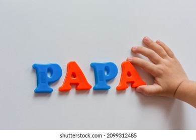 The Word PAPA Is Made Of Colored Magnetic Letters Typed By A Child's Hand. Early Development Of The Child.