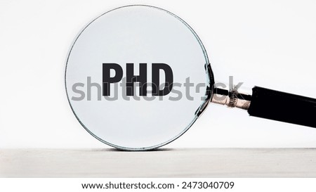 The word PHD is written text appeared looking at a white background through a magnifying glass
