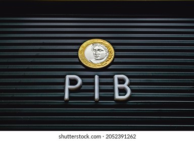 The word PIB ( gross domestic product ) formed in a lettered board with a Brazilian coin. Brazilian Portuguese language.
				