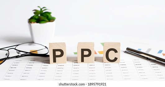 The Word PPC Formed By Wooden Blocks On A White Table on chart