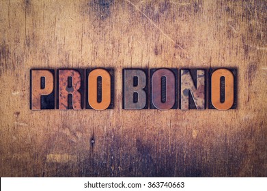 The word "Pro Bono" written in dirty vintage letterpress type on a aged wooden background.