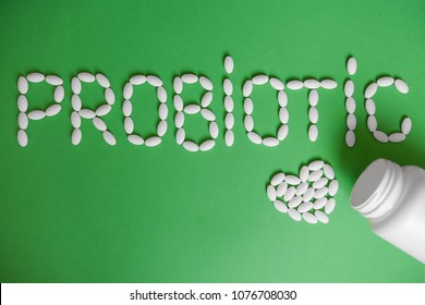 Word Probiotic On A Green Background. Probiotic Capsules For Health. The Concept Of Health