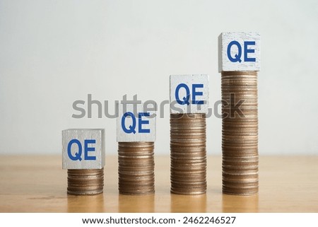 Word Quantitative Easing (QE) on stack coins as increase chart on wooden table with white wall background copy space. Central bank FED uses QE in recession economy crisis. Economic and finance concept
