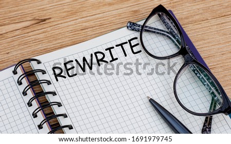 the word REWRITE is written in a notebook with glasses