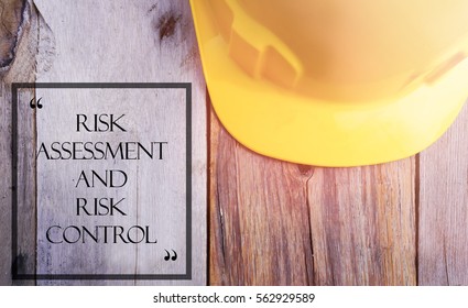 Word RISK ASSESSMENT AND RISK CONTROL With Yellow Safety Helmet On Wooden Base