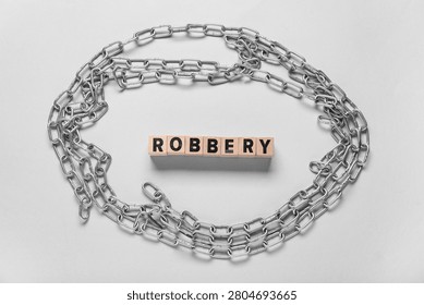 Word ROBBERY with chains on light background