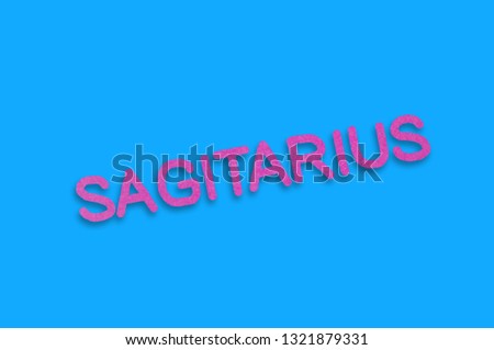 Word sagitarius cut out of purple paper on blue table. Top view. Horoscope concept