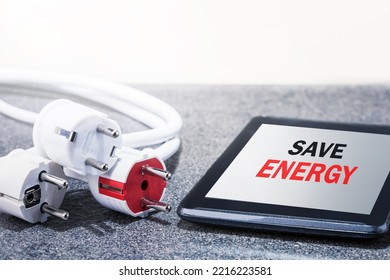 Word of save energy or used electriciyt on screen digital tablet and many electrical plugs on the desk. Save energy, electricity reduced. - Powered by Shutterstock