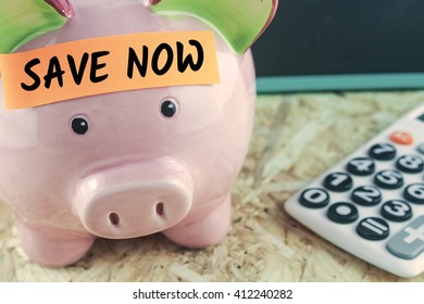 word save now on note paper on piggy bank calculator blackboard background