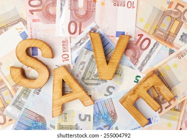 Word Save over the surface covered with the euro bank note bills