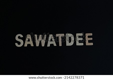 Word 'Sawatdee' on black background. Sawatdee is the word for Thai say Hello or greetings.