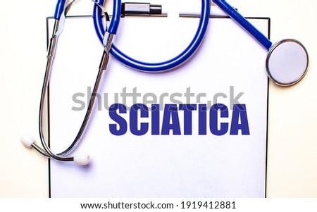 The word SCIATICA is written on a white sheet near the stethoscope. Medical concept