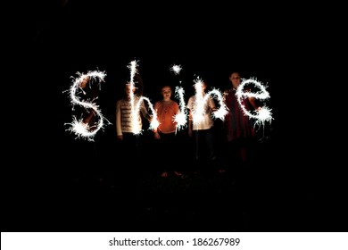 The word shine written with sparklers against a black background