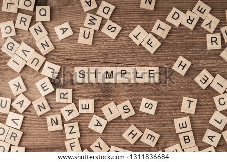 the word simple written with cube letters on wooden background