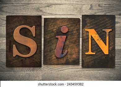 The word "SIN" written in wooden letterpress type.
