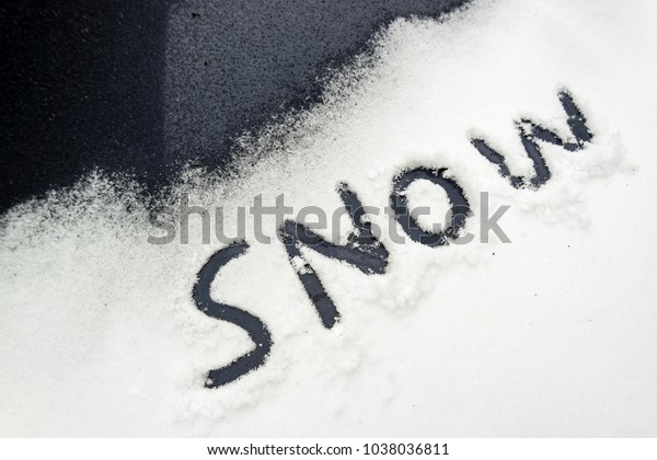 The\
word Snow written in fallen snow on a car - Oxford\
UK