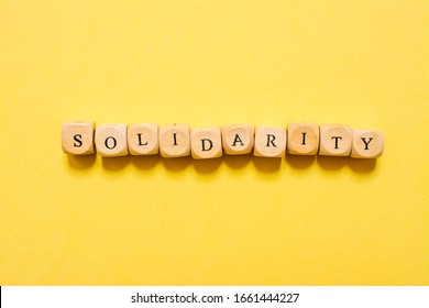 the word Solidarity, text made with dice on yellow background