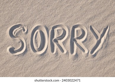 Word Sorry written on sand, close up. Concept of apologising and sorrowful mood