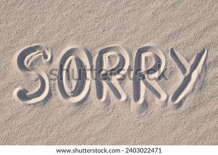 Word Sorry written on sand, close up. Concept of apologising and sorrowful mood