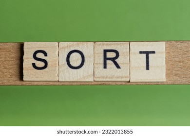 word sort made of small gray wooden letters on a green paper background