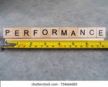 Word spelling Performance and measuring tape on bare cement or concrete wall background